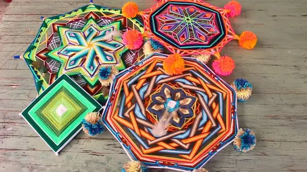 Mandala di lana di forme e colori diversi su un tavolo di legno