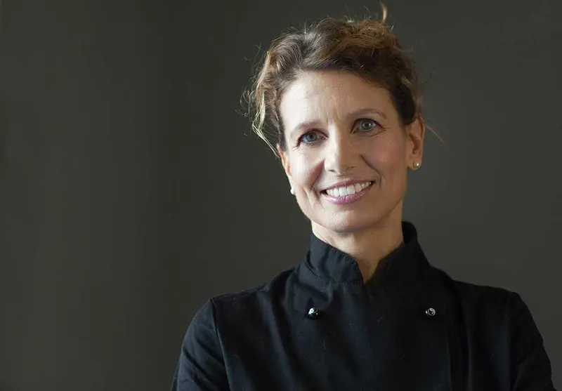 Laura Castoldi sorridente, con la giacca nera da cuoca